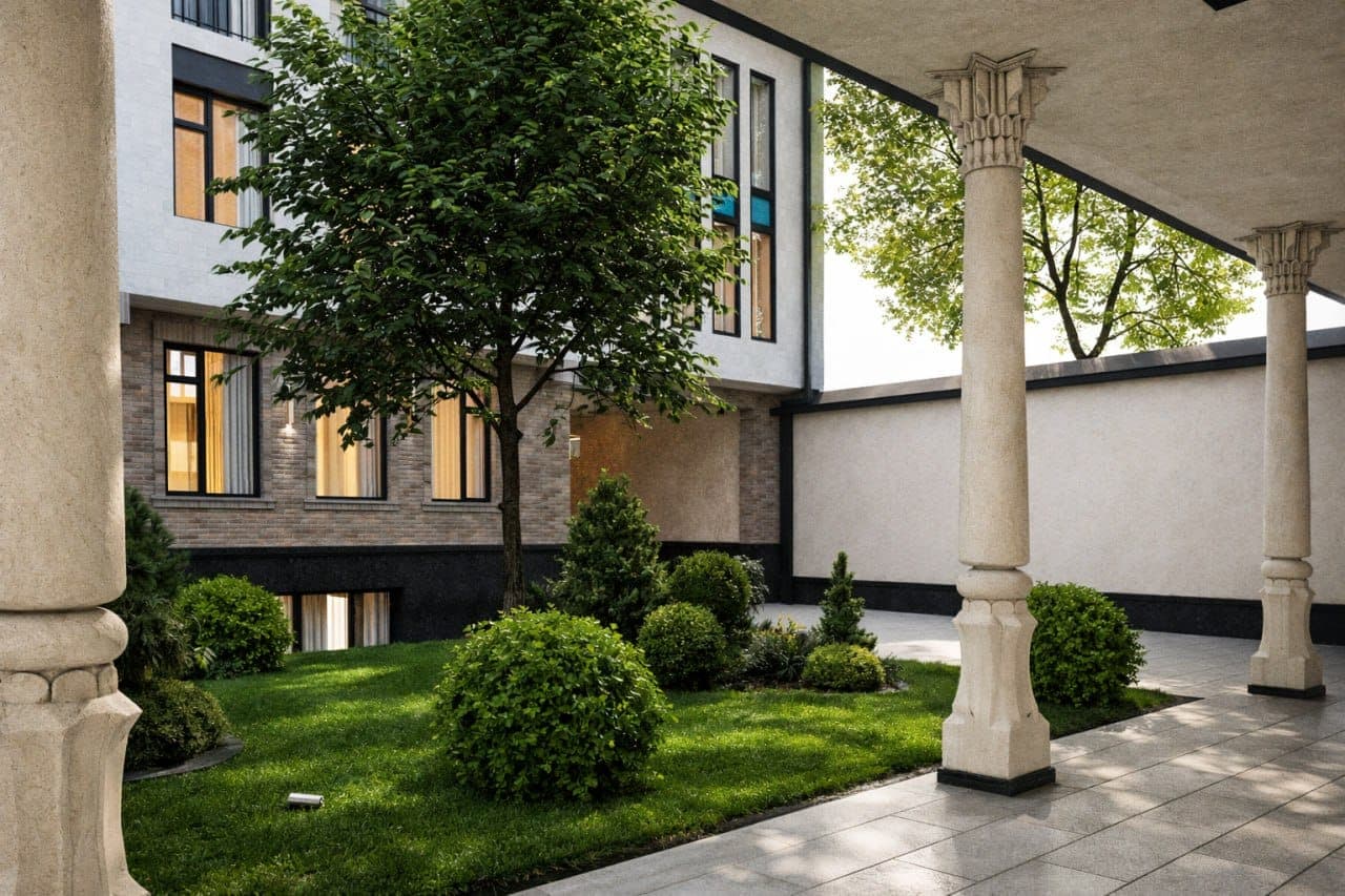 The inner courtyard, seen between the carved columns of the ayvon: a young tree, clipped shrubs and lawn, with the Academy’s windows above.